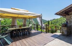 a wooden deck with a table with chairs and an umbrella at Il Casale Del Mulino in Talla