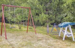 an empty playground with two swings and a slide at Il Casale Del Mulino in Talla