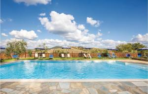 einen Pool mit blauen Stühlen und Sonnenschirmen in der Unterkunft 1 Bedroom Beautiful Apartment In Prato Dera Pi in Ulignano