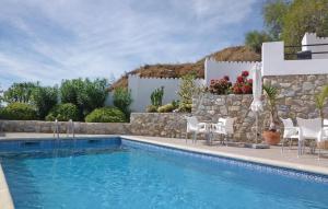 アルムニェーカルにあるAmazing Home In Almucar With 5 Bedrooms, Wifi And Outdoor Swimming Poolの白い椅子と石壁のスイミングプール