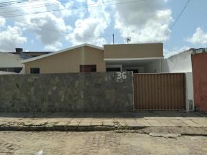 a house with a stone wall and a fence at Quarto Bem vindo in João Pessoa