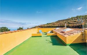 a house with a roof with two chairs and a hill at Holiday Home Hoya Los Charcos in Icod el Alto