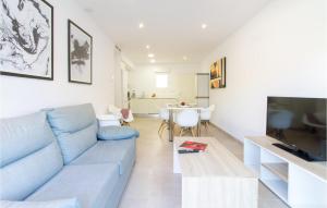 sala de estar con sofá azul y TV en 3 Bedroom Gorgeous Apartment In Denia en Dénia
