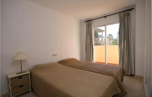マルベーリャにあるNice Apartment In Marbella-elviria With Wifi, Outdoor Swimming Pool And Swimming Poolのベッドルーム1室(ベッド1台、大きな窓付)