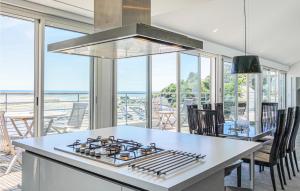 a kitchen with a stove and a table with chairs at Nice Apartment In Barneville-carteret With 4 Bedrooms And Wifi in Barneville-Carteret