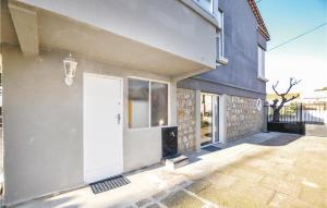 a house with a white door and a window at Cozy Apartment In Vinassan With Wifi in Vinassan