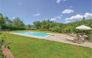 un cortile con piscina e ombrellone di Belvedere 1 a Poggioni