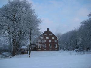 una grande casa con neve sul terreno di fronte di Wellness Sauna Beauty Farm Midwolda a Midwolda