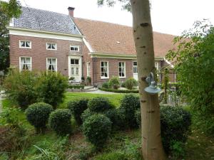 ein großes Backsteinhaus mit einem Pfahl im Hof in der Unterkunft Wellness Sauna Beauty Farm Midwolda in Midwolda + 12 Fotos