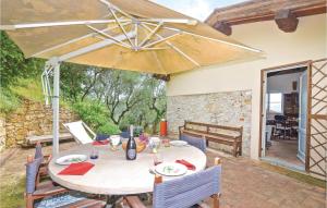 una mesa con sombrilla en el patio en Faggio, en Camaiore