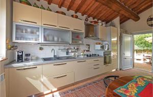 cocina con armarios blancos y techo de madera en Faggio, en Camaiore