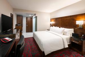 a hotel room with a large bed and a television at OTL Gouverneur Sherbrooke in Sherbrooke