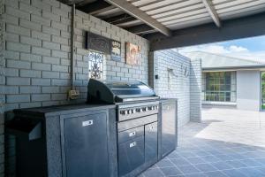 a outdoor kitchen with a stove in a patio at "Wiltara" Estate Rural Escape for 2 to 14 Guests in Orange