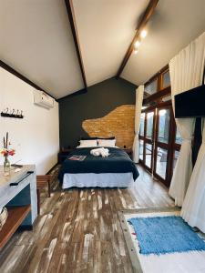 Schlafzimmer mit einem Bett und Holzboden in der Unterkunft I'Lumiar Loft in Lumiar