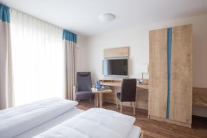 a hotel room with two beds and a desk at Sonnenhalde Landgasthof Bieg in Neuler