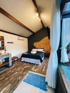 ein Schlafzimmer mit einem Bett und einem Vorhang in der Unterkunft I'Lumiar Loft in Lumiar