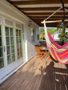 a hammock on a porch of a house at Charmant bungalow du Moule in Le Moule