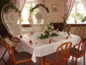 a table with white chairs and a white table cloth at Zeesener Gasthof in Königs Wusterhausen