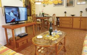 a living room with a television and a table with a bottle of wine at Urb, Al Andalus I in Villamartin