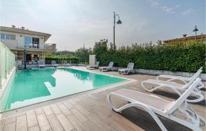 einen Pool mit Liegestühlen neben einem Haus in der Unterkunft Pet Friendly Apartment In Puegnago Sul Garda With Outdoor Swimming Pool in Raffa