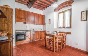 een keuken met houten kasten en een tafel met stoelen bij Camelia in Lucolena in Chianti