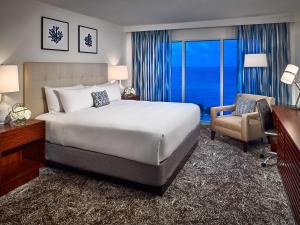 a bedroom with a bed and a desk and a chair at Sonesta Fort Lauderdale Beach in Fort Lauderdale