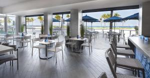 a restaurant with tables and chairs with a view of the ocean at Sonesta Fort Lauderdale Beach in Fort Lauderdale