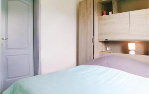1 dormitorio con 1 cama con puerta y armario en Lovely Home In St Urbain With Kitchen, en Saint-Urbain