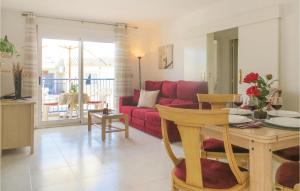 sala de estar con sofá rojo y mesa en Amazing Apartment In Torrevieja With Kitchen, en Torrevieja