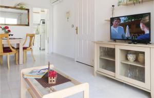 sala de estar con TV y mesa en Amazing Apartment In Torrevieja With Kitchen, en Torrevieja