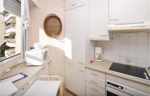 uma cozinha com armários brancos e um lavatório em Awesome Apartment In Cannes With Kitchen em Cannes