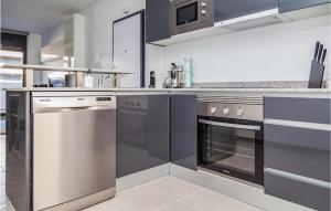 une cuisine avec des appareils en acier inoxydable et une cuisinière dans l'établissement Cozy Apartment In Los Arenales Del Sol, à Arenales del Sol
