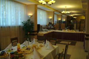 a dining room with tables and chairs with food on them at HotelsLublin in Lublin