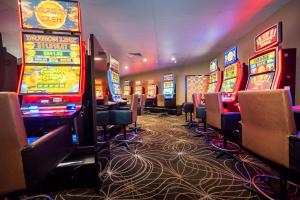 un casino avec de nombreuses machines à sous dans une pièce dans l'établissement Shamrock Gardens Motel, à Mackay