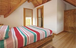 una camera da letto con un letto con un piumone colorato a righe di Awesome Home In Belluno Bl With Wifi a Lèvego