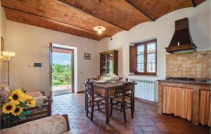 an open kitchen with a wooden table and chairs at Cortilla 1 in Cinigiano