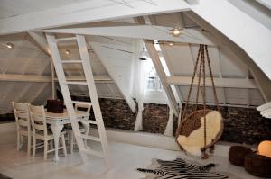 a room with a table and chairs and a swing at Attic Room Judy's in Zandvoort