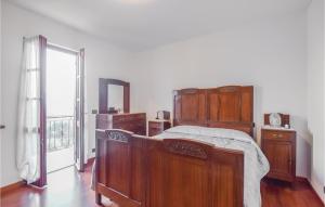 um quarto com uma cama de madeira e uma janela em Casa Giovanni em Tavarone