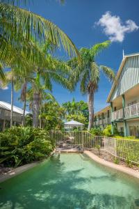 
a beach with palm trees and palm trees at Shamrock Gardens Motel in Mackay
