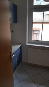 ツヴィッカウにあるschöne 2 Zimmerwohnungの窓付きのキッチン、青いキャビネットが備わります。