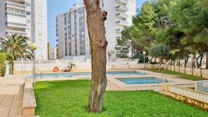 a swimming pool in a park with a tree at EUROPA I - Playa de Miramar in Miramar