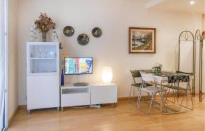 a room with a refrigerator and a table with chairs at Nice Apartment In Sant Feliu De Guxols With Kitchen in Sant Feliu de Guixols