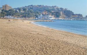 una playa con gente caminando por la arena y el agua en 1 Bedroom Cozy Apartment In Sant Feliu De Guxols, en Sant Feliu de Guíxols