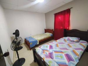a bedroom with two beds and a red curtain at apartamento #4 completo y cómodo in Ríohacha