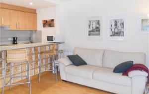 a living room with a white couch and a kitchen at Nice Apartment In Sant Feliu De Guxols With Kitchen in Sant Feliu de Guixols