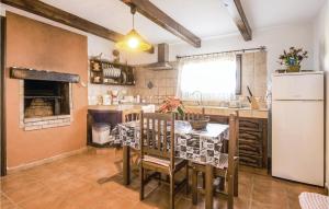 a kitchen with a table and a white refrigerator at Stunning Home In Icod El Alto With House A Mountain View in Icod el Alto