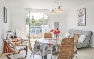 Hauteville-sur-MerにあるAmazing Apartment In Hauteville-sur-mer With 2 Bedrooms And Wifiのリビングルーム(テーブル、椅子、ソファ付)