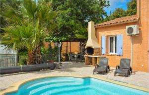 a swimming pool with two chairs and a house at Gorgeous Home In Montignargues With Kitchen in Montignargues