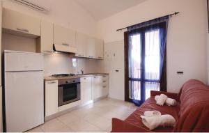 eine Küche mit einem Sofa, einem Kühlschrank und einem Fenster in der Unterkunft Beautiful Apartment In Costa Rei -ca- With Wifi in Monte Nai