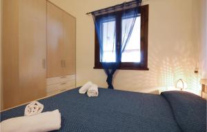 a bedroom with a blue bed with towels on it at Beautiful Apartment In Costa Rei -Ca- With Wifi in Monte Nai +9 photos